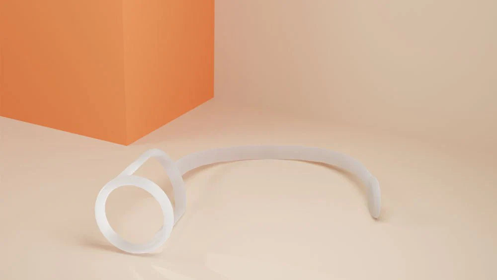 The Xialla device on a plain background: a soft silicone ring attached to a flexible anchoring strap.